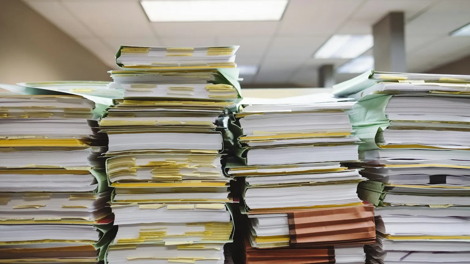 Pilhas de documentos em papel e pastas de arquivo